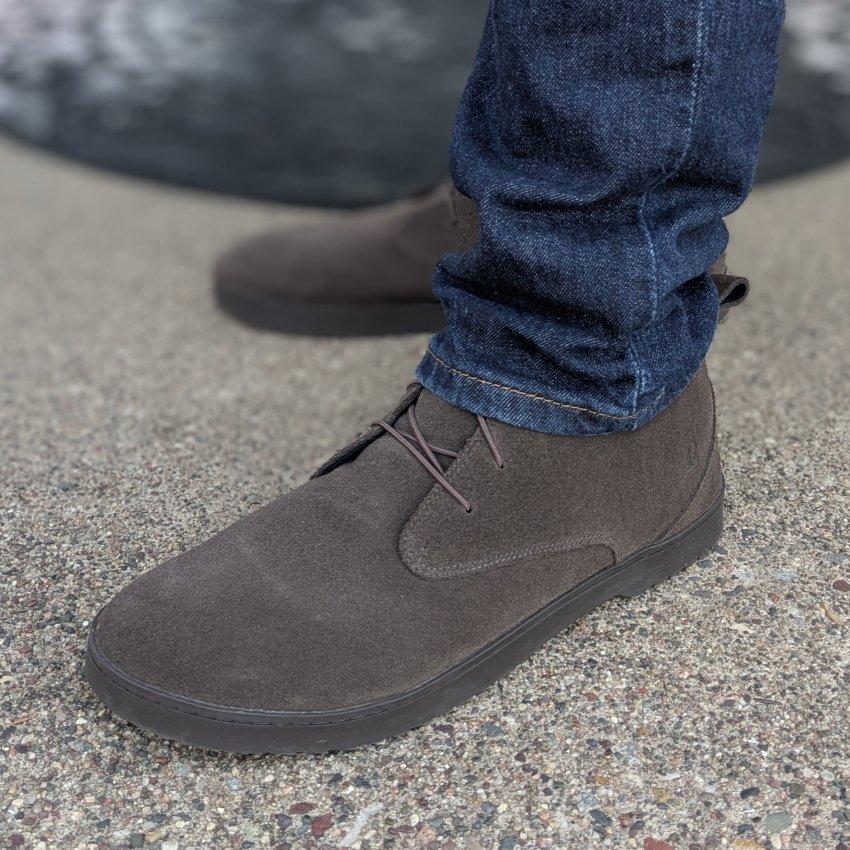 A close up image of dark brown high quality suede Carnforth chukka boots from Birchbury. The side faux heel outsole is visible along with the wide toe box and elastic laces