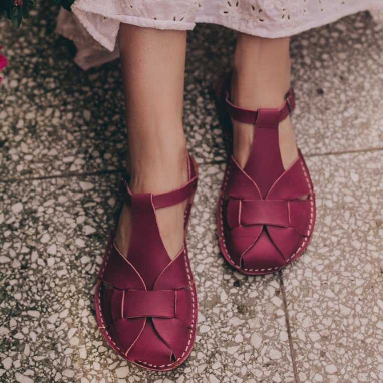 Top down view of Crupon Sandals Abbie leather barefoot closed toe sandals in Marsala color. The edge of a white eyelet dress is visible at the top of the frame.
