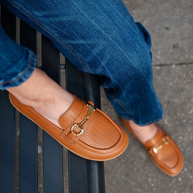 Top down view of a person's feet in Be Lenka Divella woven detail loafers. Wide toe box comfortable loafers in cognac leather