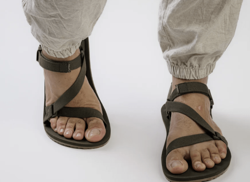 A front view of a person walking in Rutsu Nature Sandals, a barefoot flexible sandal without a toe post