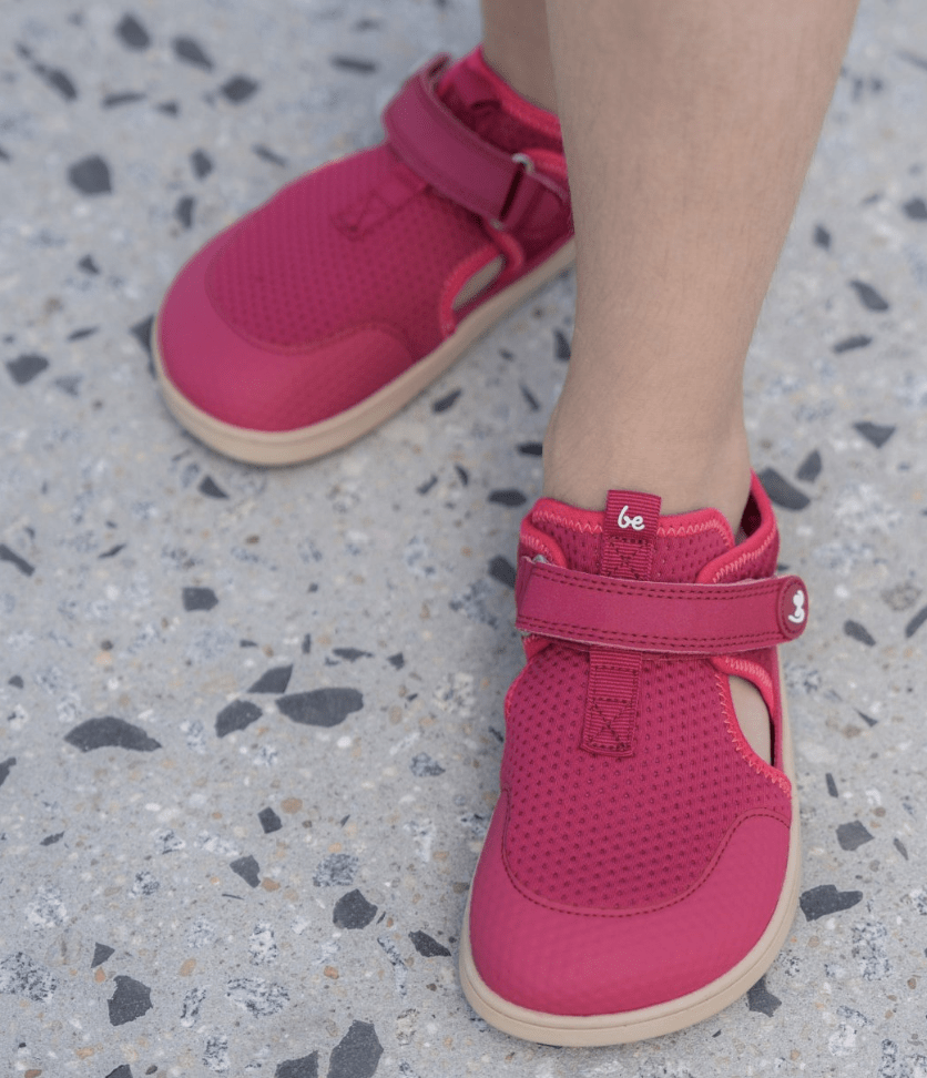 A pair of closed-toe sandal style Be Lenka kids shoes with a wide toe box in pink.