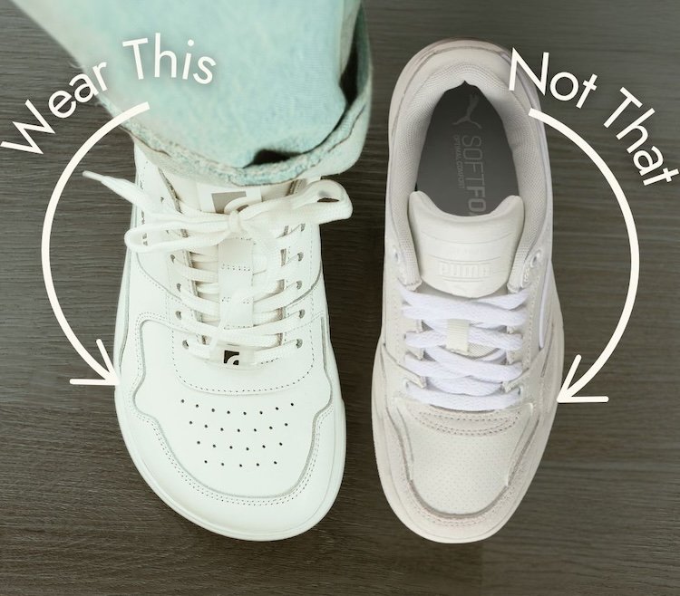 A top down view of two shoes. One is a barefoot shoe, the Barebarics white leather Zing sneaker next to a similar style shoe but with a pointy toe box. Text over the image is "Wear this" next to the foot shaped shoe and "not that next to the pointy shoe.