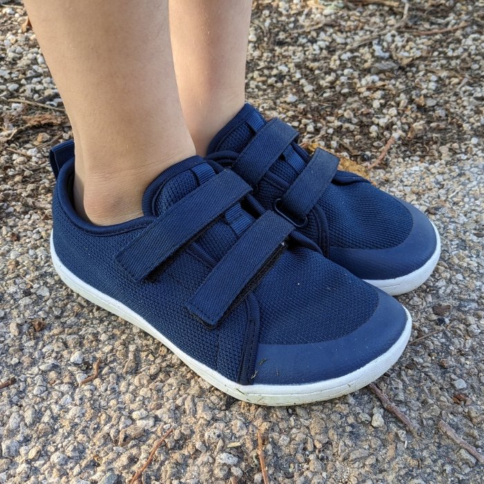 Close up side/front view of a pair of navy blue mesh wide toe box sneakers from Whitin on Amazon, an affordable barefoot shoe brand for kids and adults