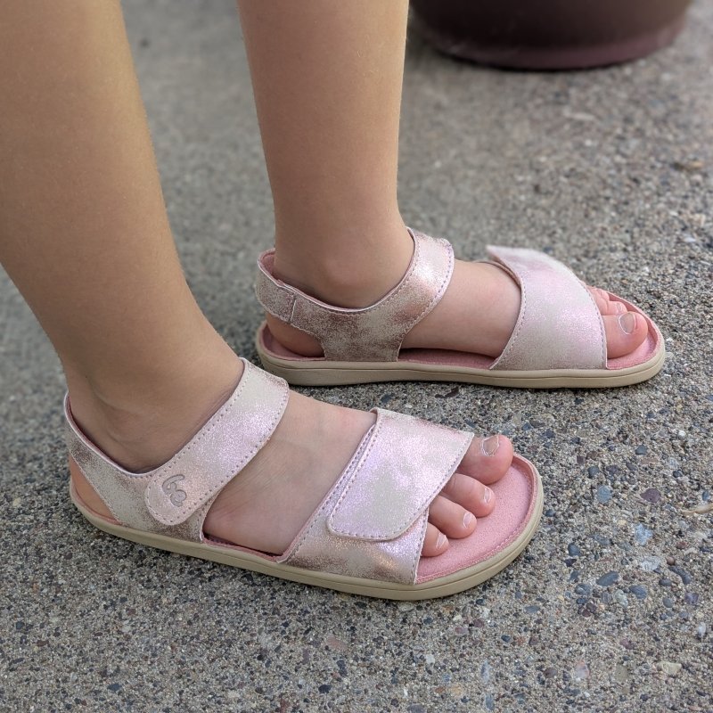 Side close up of a child's feet in Be Lenka Miami kids barefoot sandals in a pink shimmery vegan material