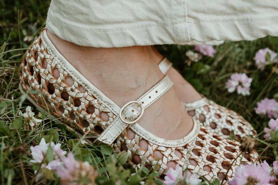 Close up of the woven leather details on a pair of Origo ballerinas in gold with on a zero drop flexible sole