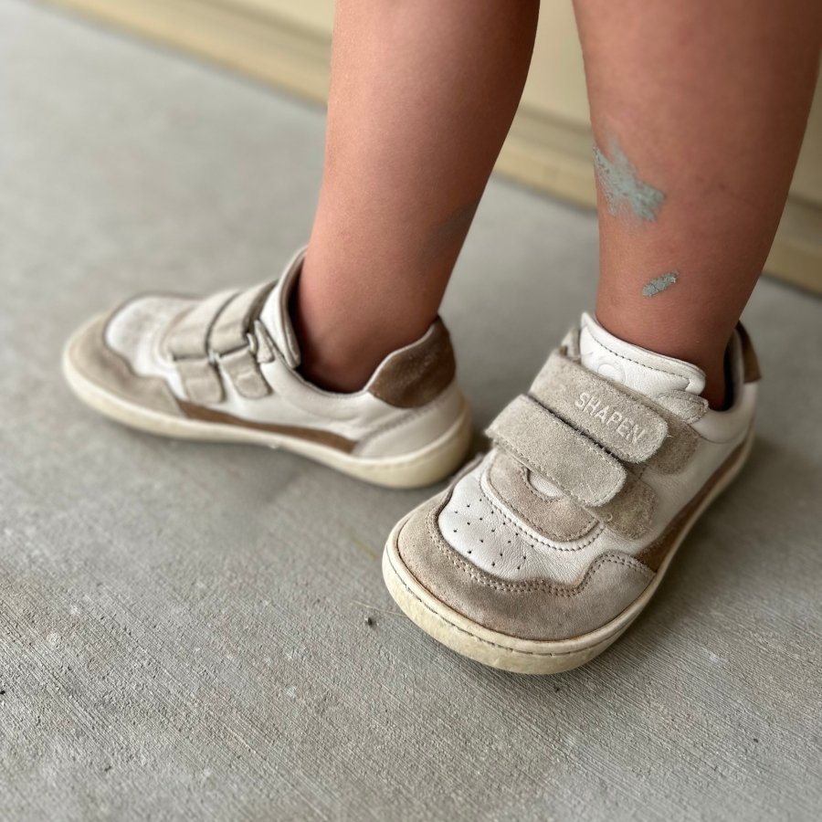 A pair of well worn Shapen barefoot kids sneakers with a wide toe box and velcro straps