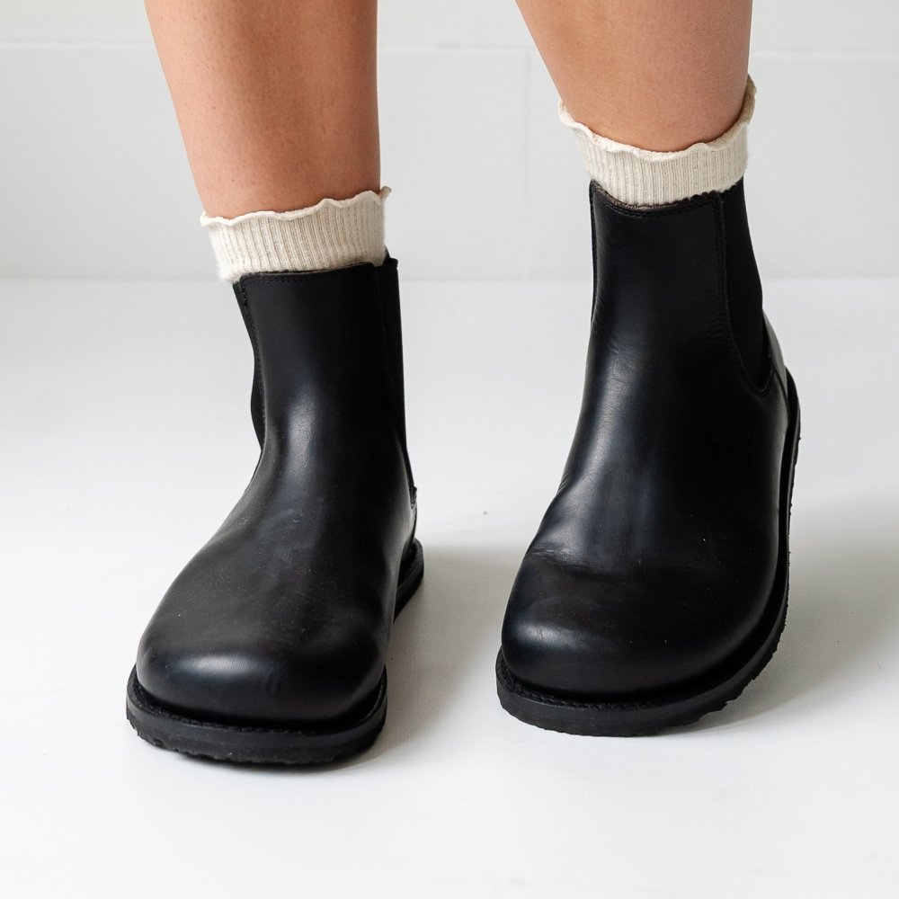 A front view of a person's feet in black classy barefoot leather chelsea boots from Gaucho Ninja with a wide toe box