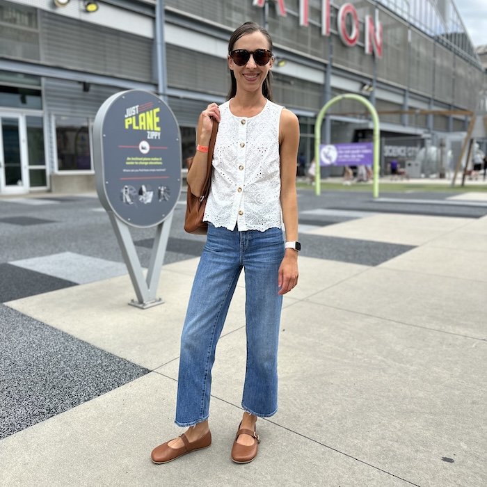 A woman in front of a museum wearing brown leather wide toe box Origo Shoes barefoot mary jane flats