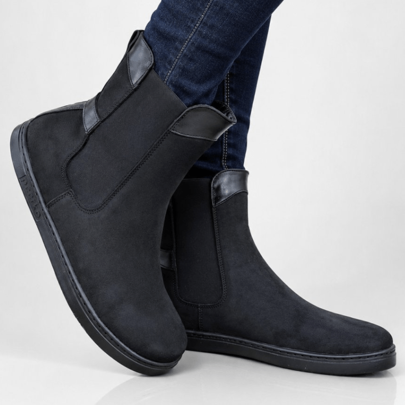 Side view of a person wearing Peerko Chelsea Black Suede barefoot boots