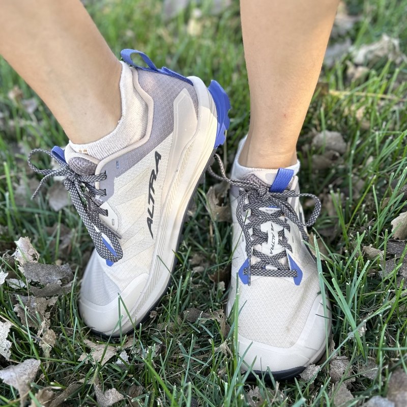 A front and side view close up of a pair of legs in Altra Lone Peak hiking sneaker.