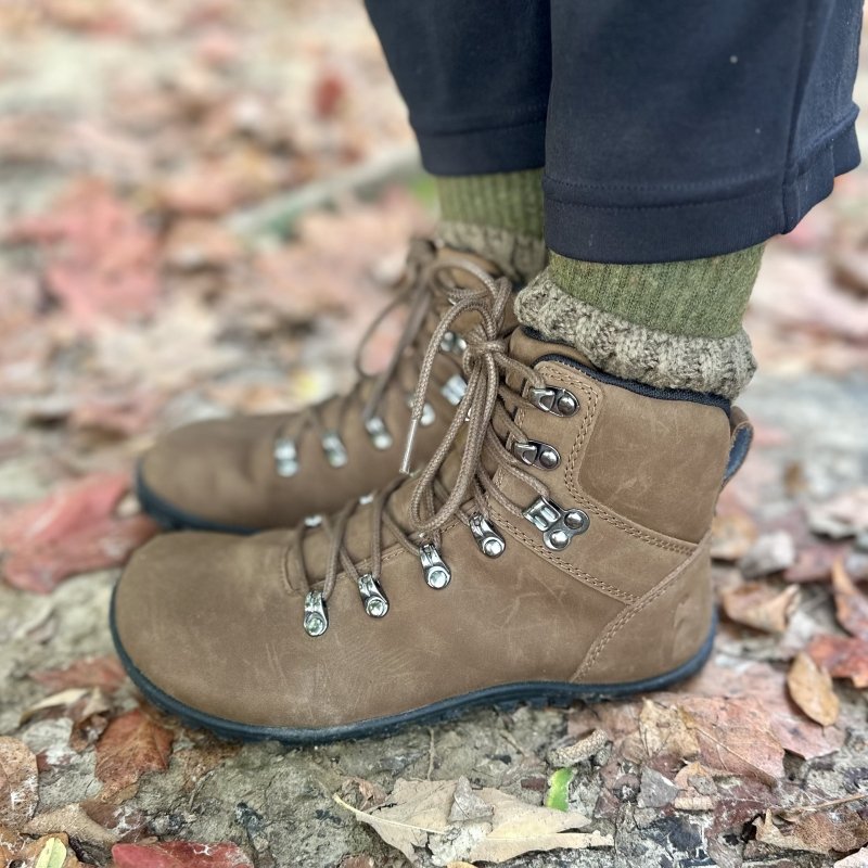 Side close up of Freet Chamois barefoot hiking boots with silver grommets. The padded ankle collar has chunky socks showing above them.