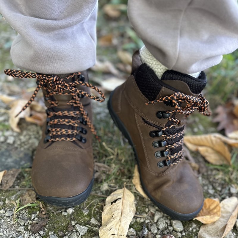 A close up of a pair of Groundies Portland barefoot hiking boots. one foot is tilted to the side and flexed to demonstrate the sole flexibility
