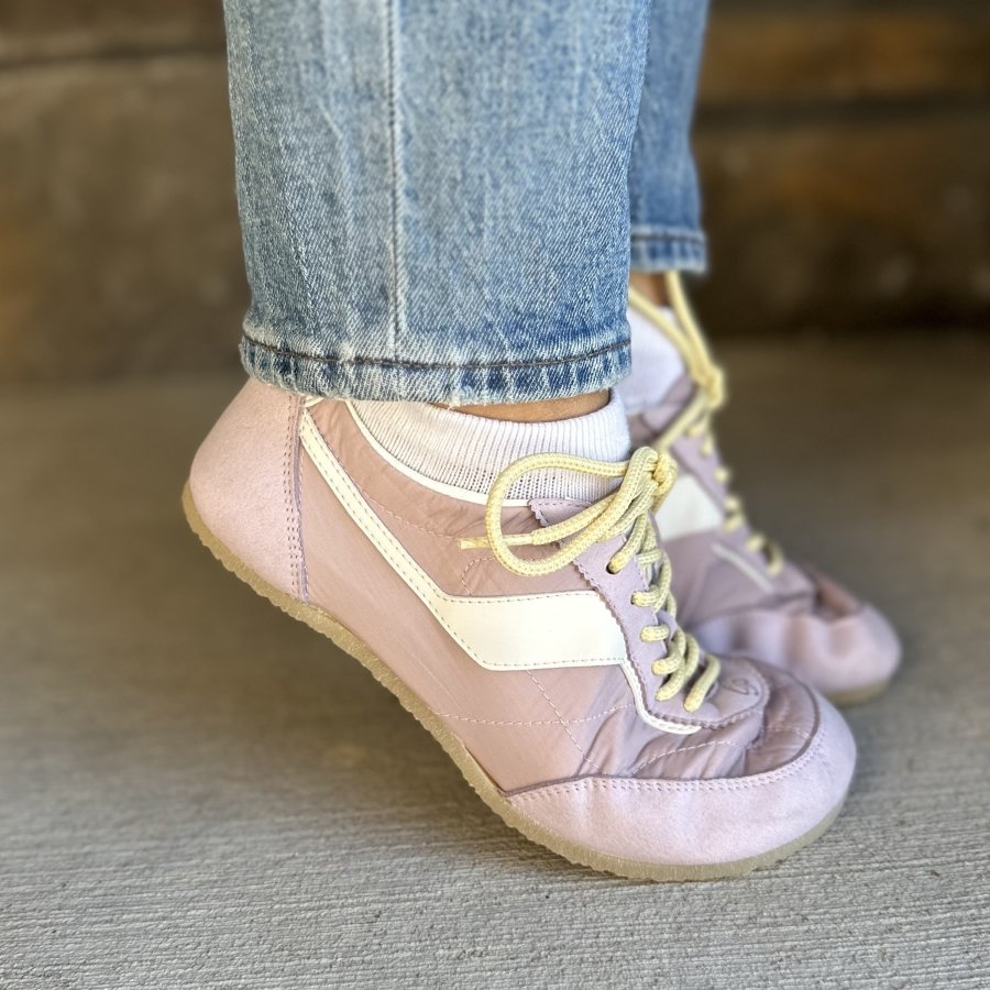 A side view of a pair of Ohne Project Sneakerinas on a really thin flexible outsole being flexed up on tip toes. The light lavender sneakerinas are made with a quilted fabric.