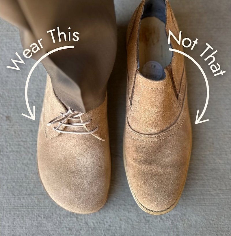 A top down view of two shoes side by side. On the left is the Origo Men's barefoot derby dress shoe in a taupe suede with a wide toe box. To the right is a conventional men's dress shoe in the same leather type but with a pointy narrow toe, and the words "Wear this, not that" super imposed over the image