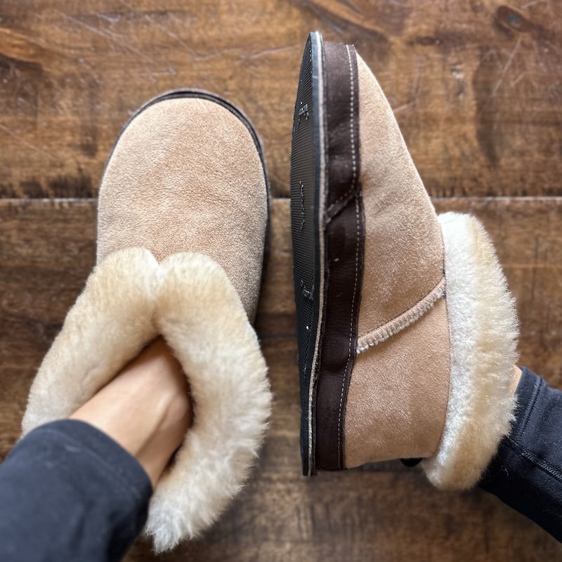A top down and side view of Softstar S'More fireside slippers with a rubber outsole, made with genuine sheepskin. The slipper on the right is sitting on it's side to show the fluffy profile and the left foot is upright to show the overall shape.