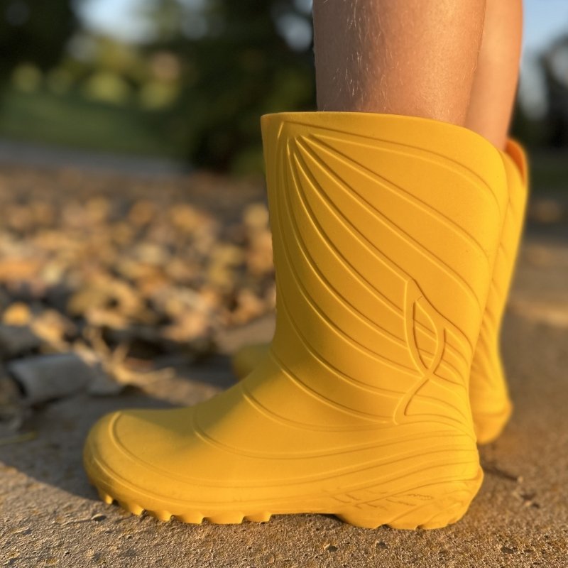 A pair of children's Wildling Ranidae rain boots in classic yellow with a zero drop flexible outsole