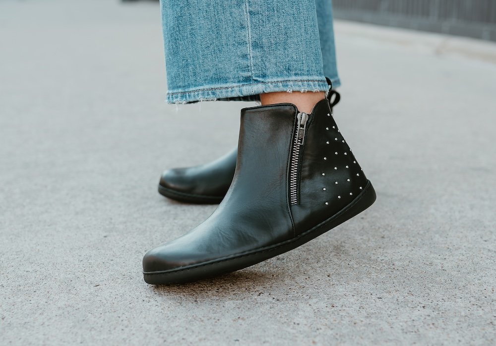 Close up of Zaqq Qlare, a studded heel wide toe box black leather ankle boot with side zip.
