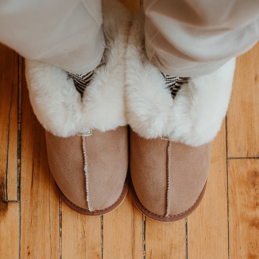 Close up of barefoot Zeazoo Dolly sheepskin slippers with a rubber outsole in chestnut color