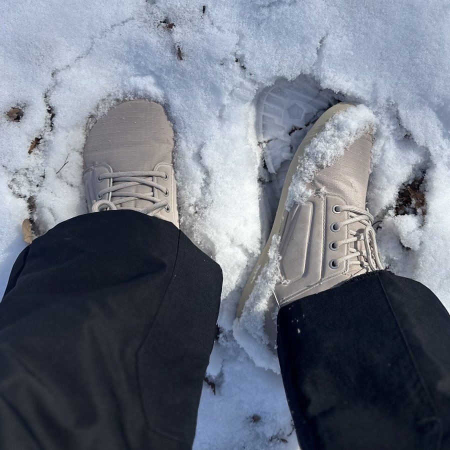 A close up of a person in wide snow pants and Be Lenka barefoot Arctic Edge snow boots with a wide toe box and flat outsole