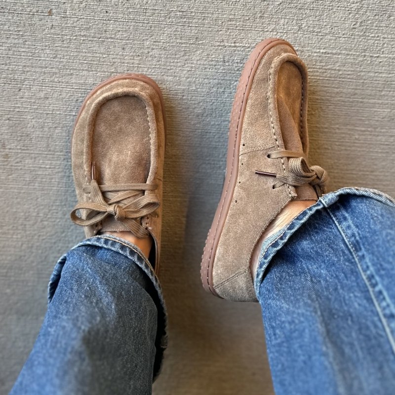 A top down and side look at a pair of Raum Goods Mecca moccasin style barefoot shoes in a light brown suede. A pair of cuffed wide leg jeans are worn with the wide toe box trendy shoes.