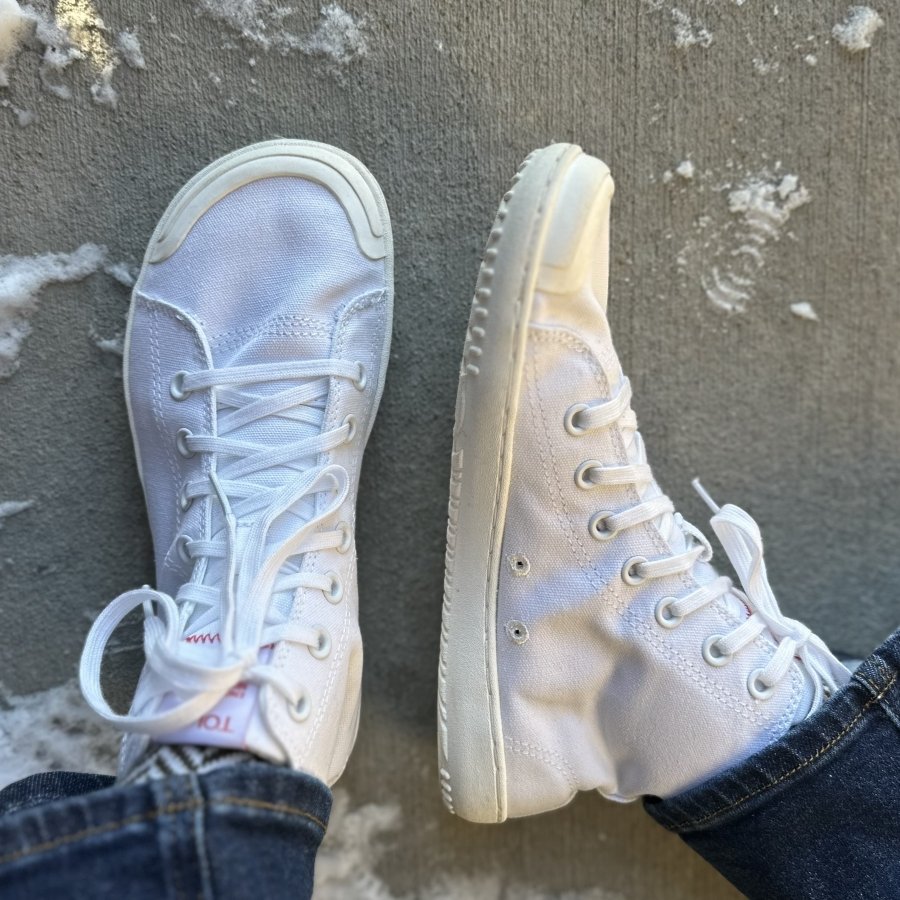 A pair of Tolos Canvas High barefoot Transition Sneakers with a wide toe box. The right shoe is being splayed out to the side to show the profile.