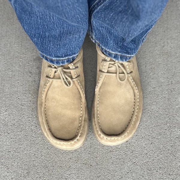 Top down view of a pair of Groundies Cricket top stitch moc style barefoot shoes with a wide toe box in beige suede.