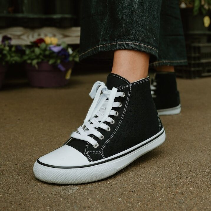 A side close up view of a pair of Bohempia barefoot high top Orik black hemp canvas sneakers with a wide toe box