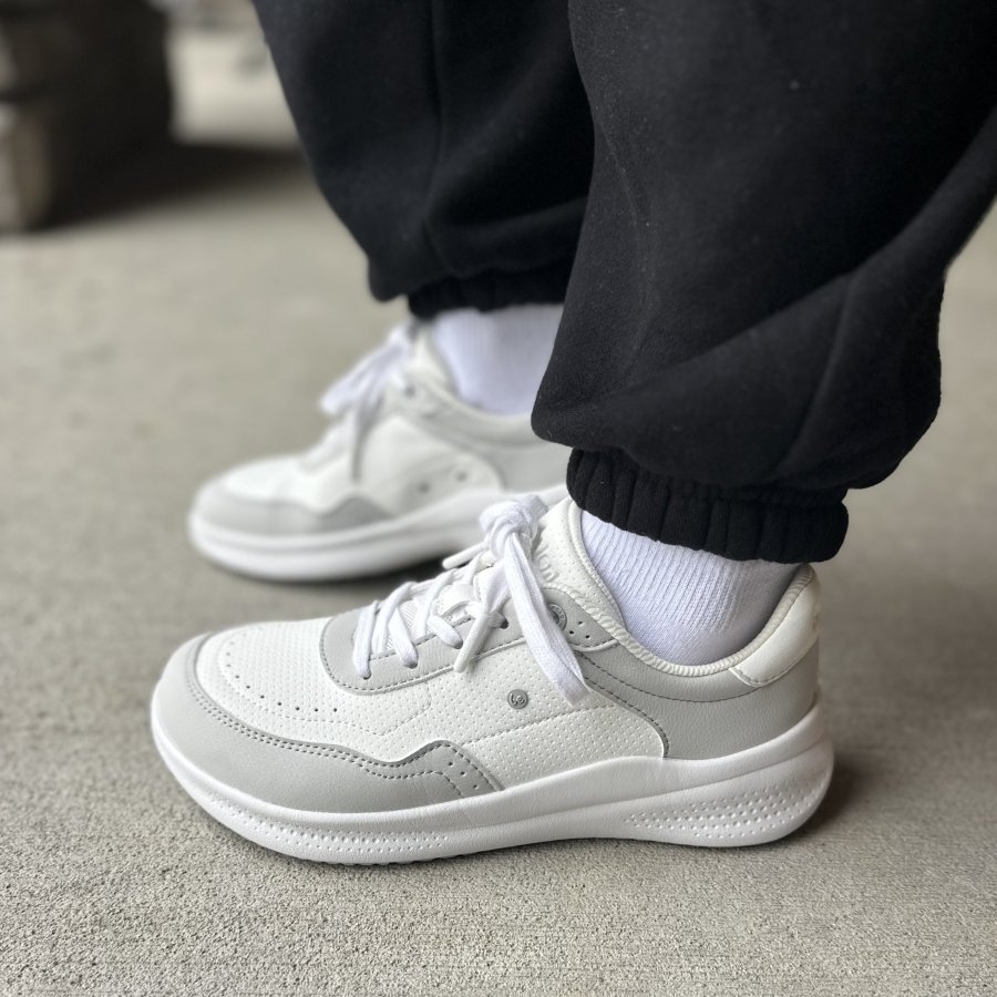 Side view of a person's feet in Be Lenka Recovery wide but not barefoot sneakers.