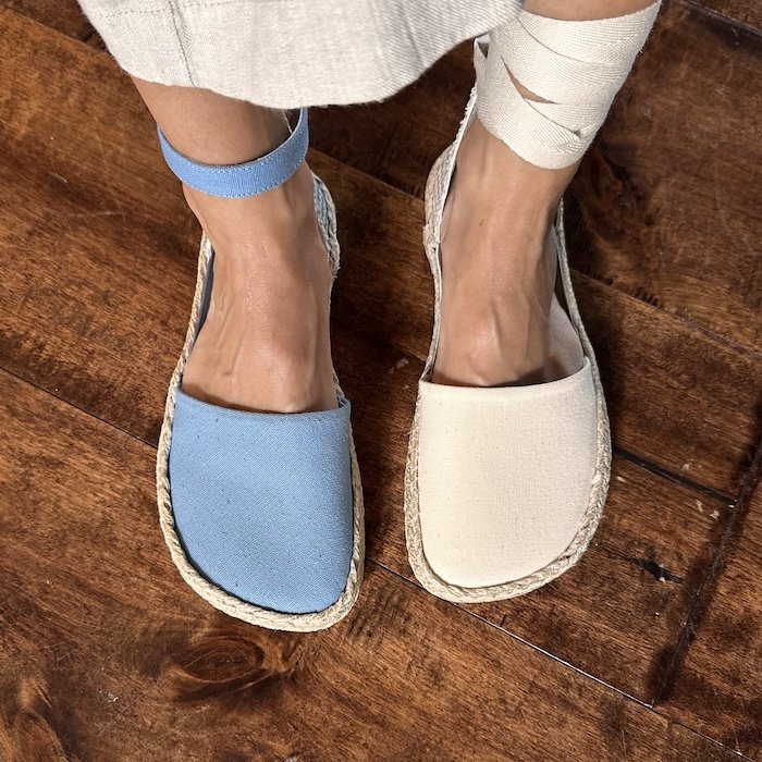 A top down view of a person wearing two different colors of Shapen Barefoot Festa espadrilles in wide