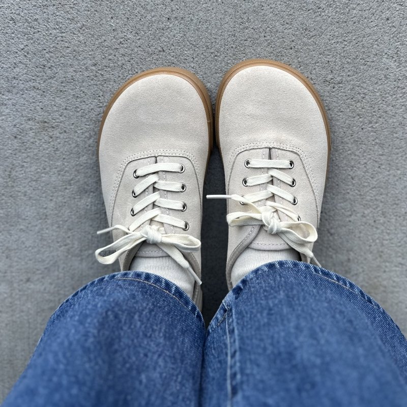 A top down view of a person's feet in Zara Barefoot Sneakers with a wide toe box and plain neutral look.