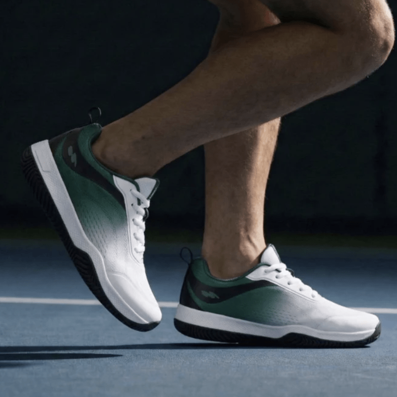 Side view of a person walking on a court in Cuurt Barefoot Tennis sneakers in a green to white colorway with a zero drop outsole