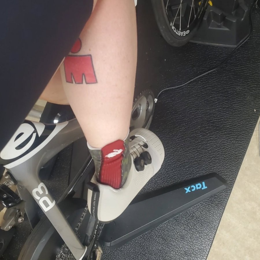 A back view of a person on a bike trainer wearing a pair of Strong Feet Athletics Leviathan wide toe box cycling shoes for triathalon training