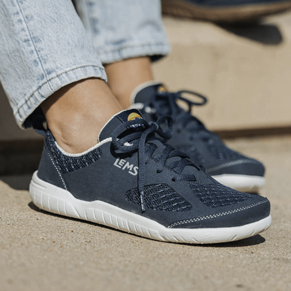 Side close up of a person's feet in Lems Primal 3 Navy wide toe box all around barefoot shoes for training