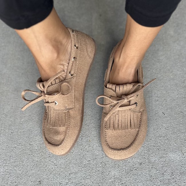 A top down and slightly side view of pair of vegan barefoot boat shoes from Clotsy with tassles eyelets, and a wide toe box