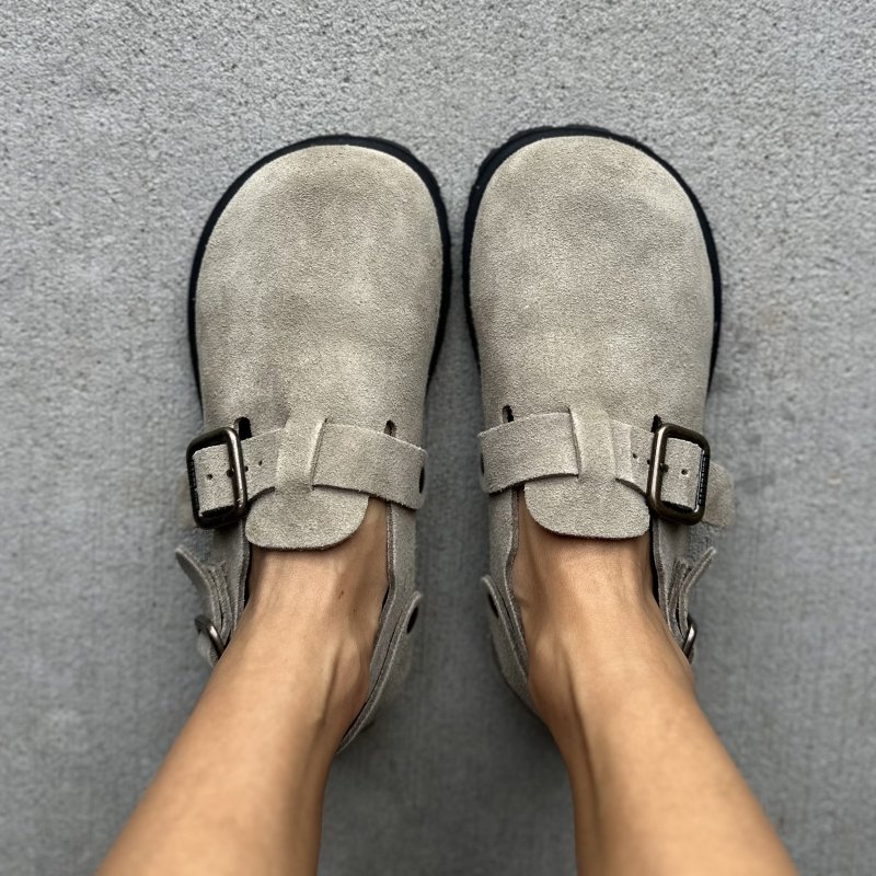 A top down view of a person's feet in Barebound Ikarus II barefoot clogs in tan suede with a wide toe box