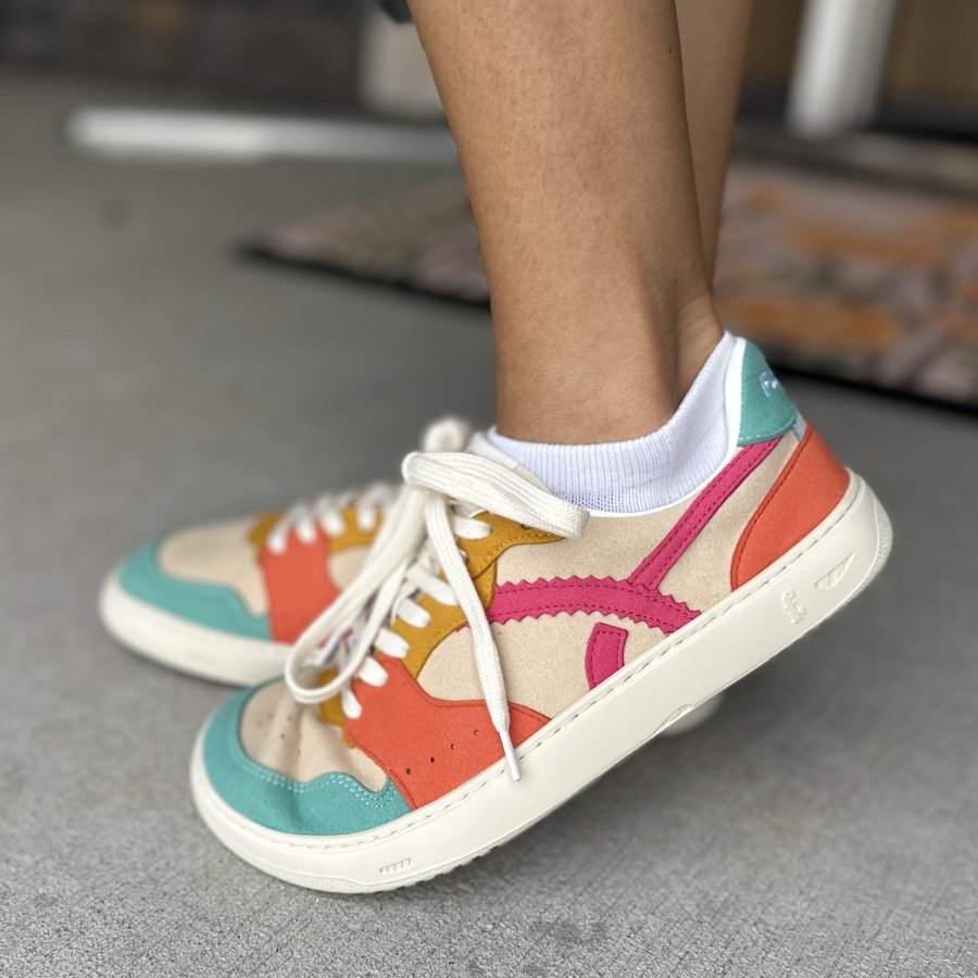 A close up of a pair of colorful barefoot sneakers from Fleeters. The Mango Lagoon colorway includes orange, yellow, pink, and seafoam accents