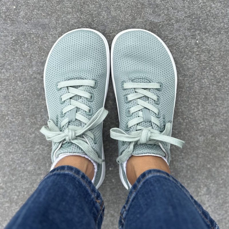 A top down view of a person in mint colored mesh sneakers from Skinners. Slightly lighter colored laces and an anatomical toe box complete the look.