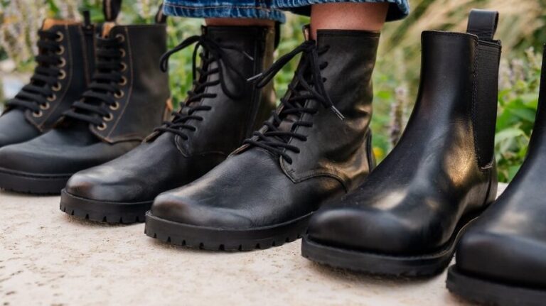 A trio of black barefoot boots with a person standing in the middle pair - Lang.S Kombat. Gaucho Ninja and El Naturalista brands are on the sides.