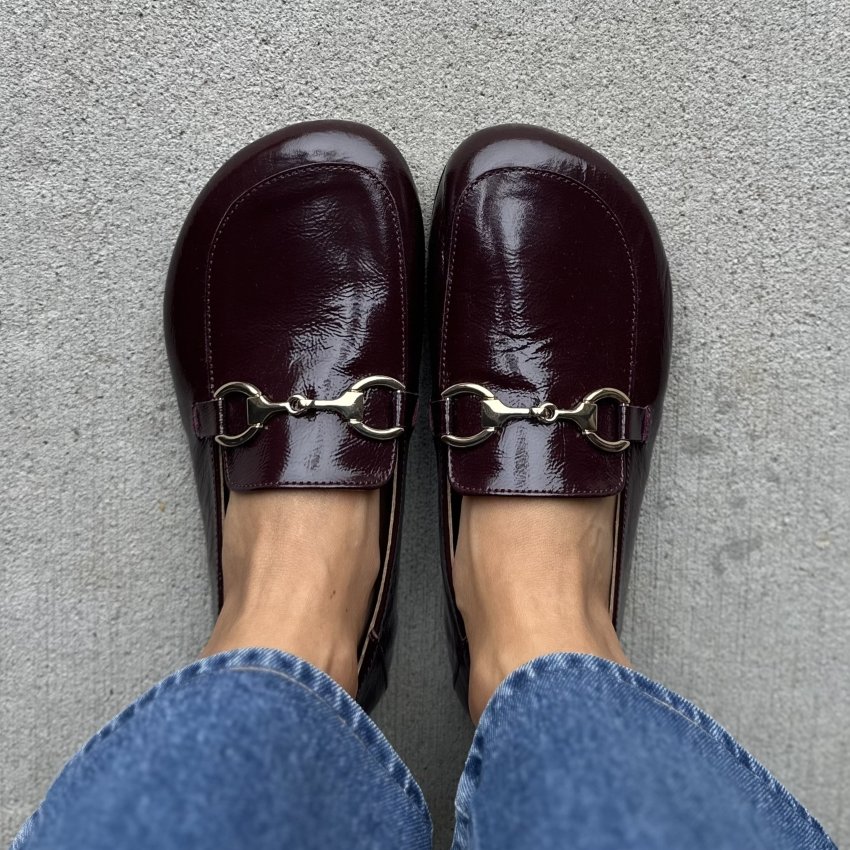 Top down view of a person in Paidal loafers in a rich deep red leather with a silver buckle detail