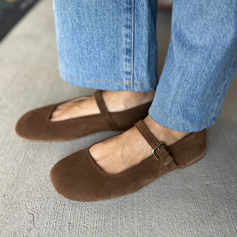Side view of a pair of brown suede Peralba mary jane flats with a wide toe box.
